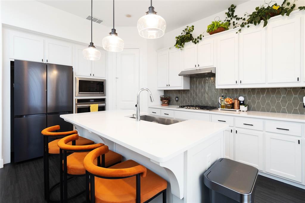 a kitchen with stainless steel appliances a stove a sink and a refrigerator