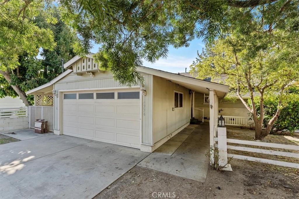 a front view of a house with a tree