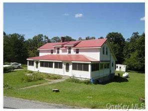 View of front facade with a front yard and a sunroom