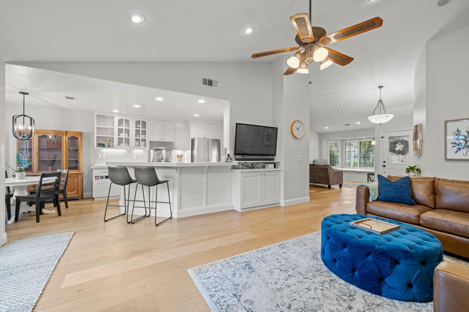 a living room with furniture kitchen view and a wooden floor