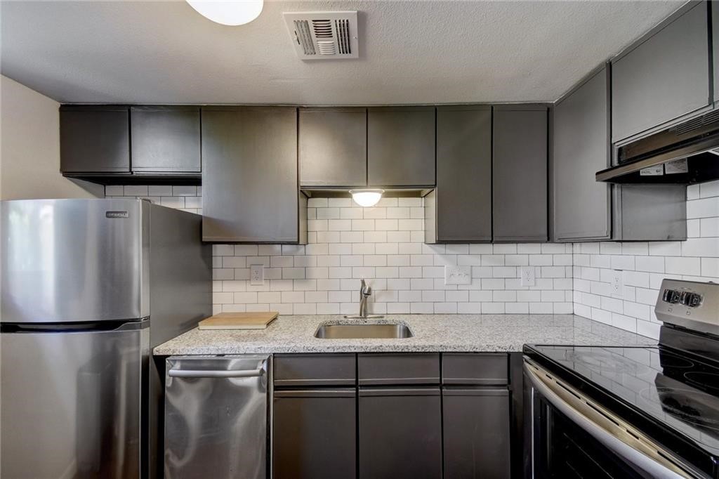 a kitchen with stainless steel appliances a sink stove and refrigerator