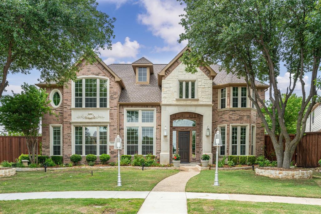 front view of a brick house with a yard