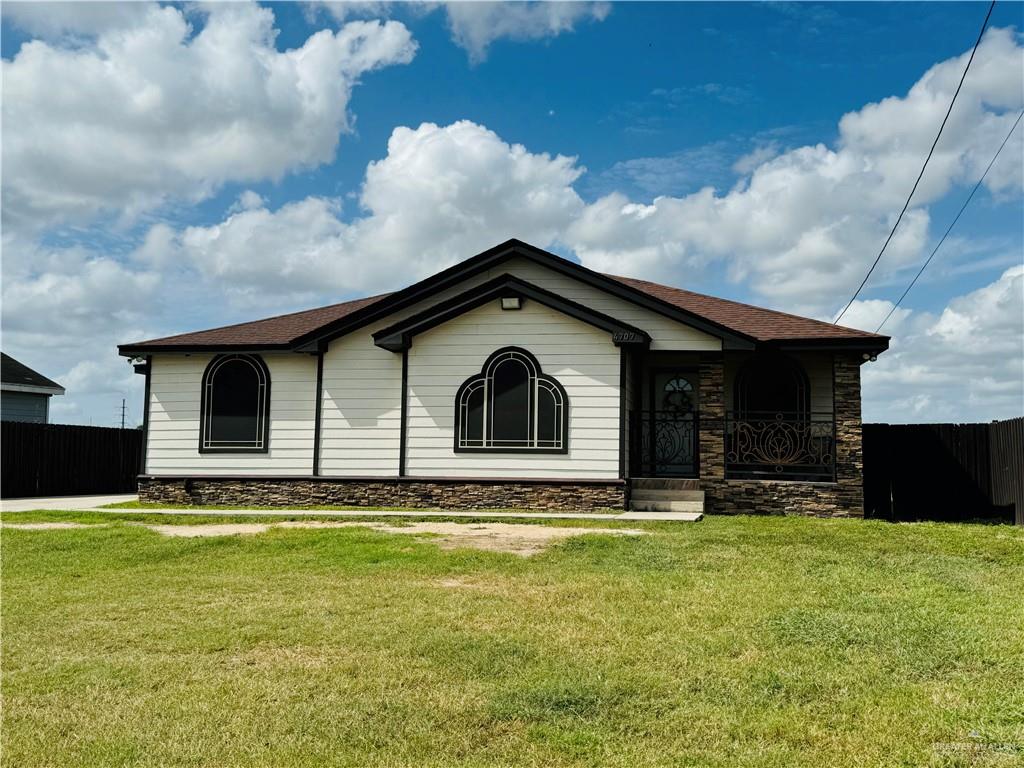 a view of house with yard and sitting area