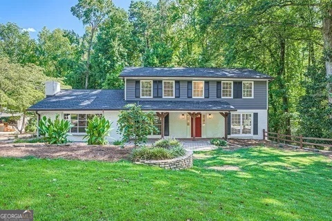 a front view of a house with a yard and trees