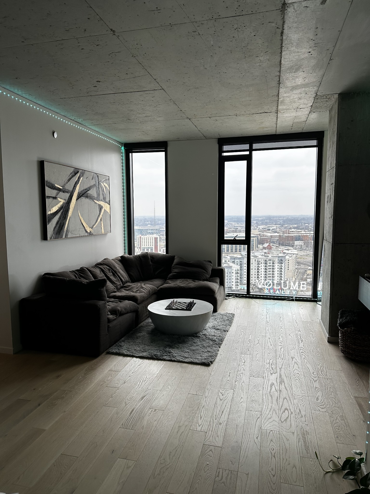 a living room with furniture large window and flat screen tv