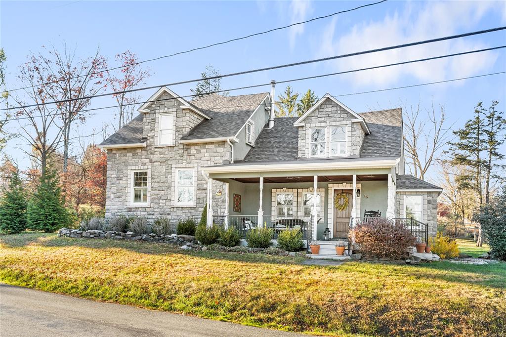 Cape cod house featuring a porch and a front yard