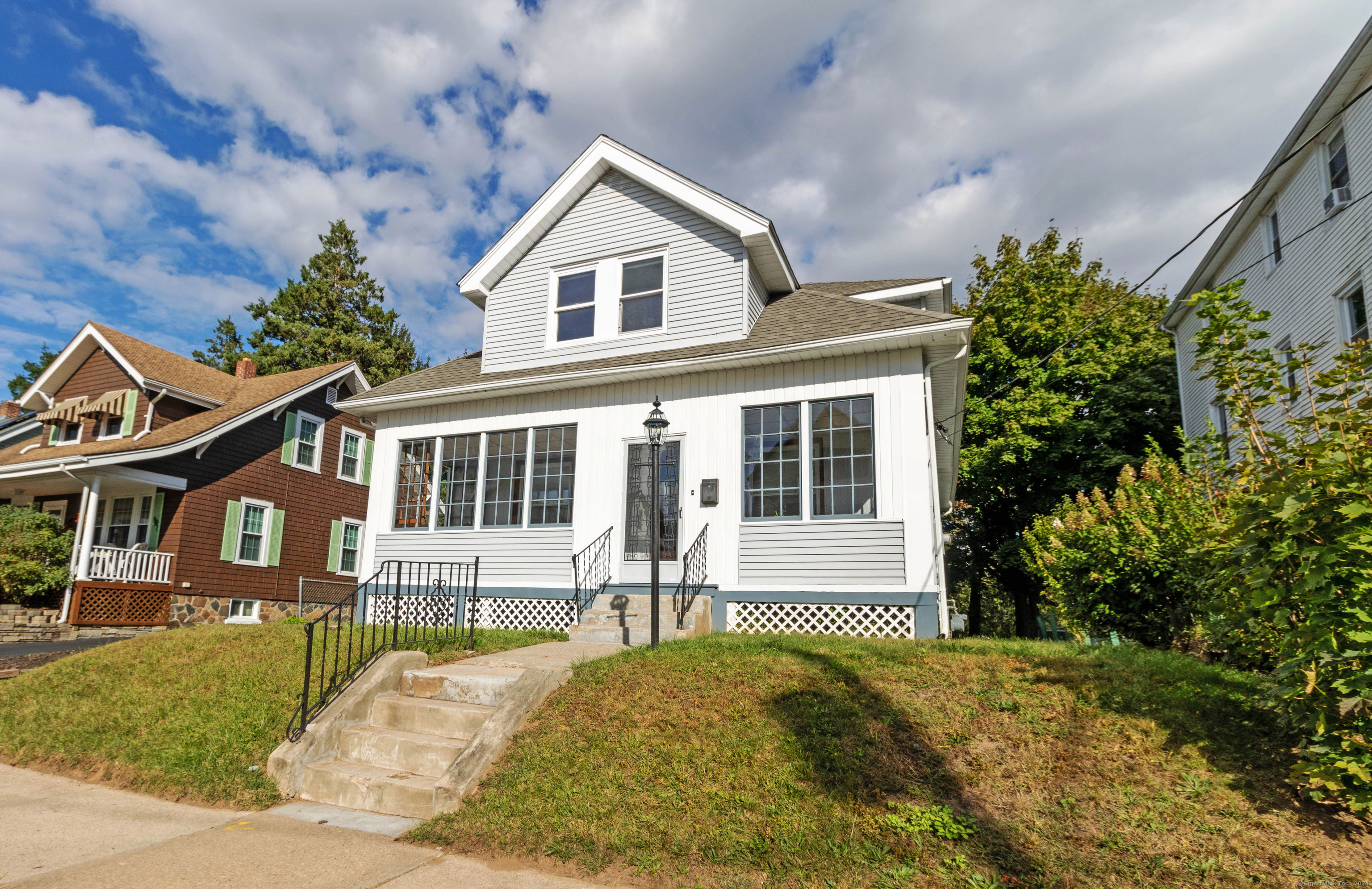 a front view of a house with a yard and trees