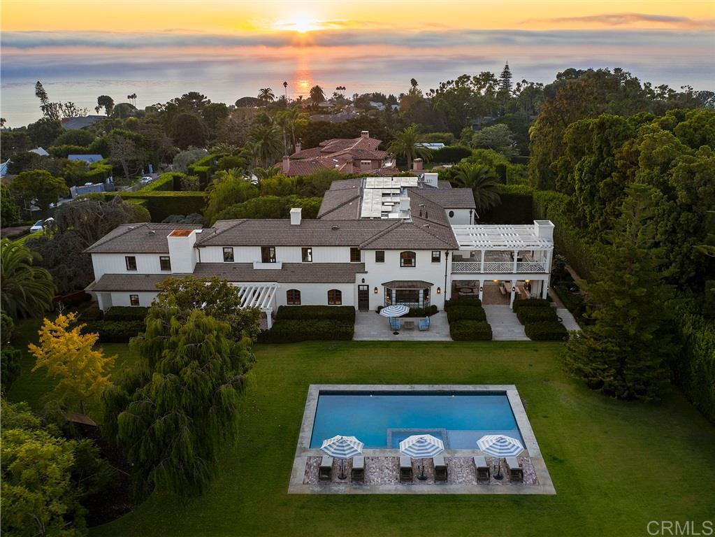 an aerial view of a house with a garden and lake view