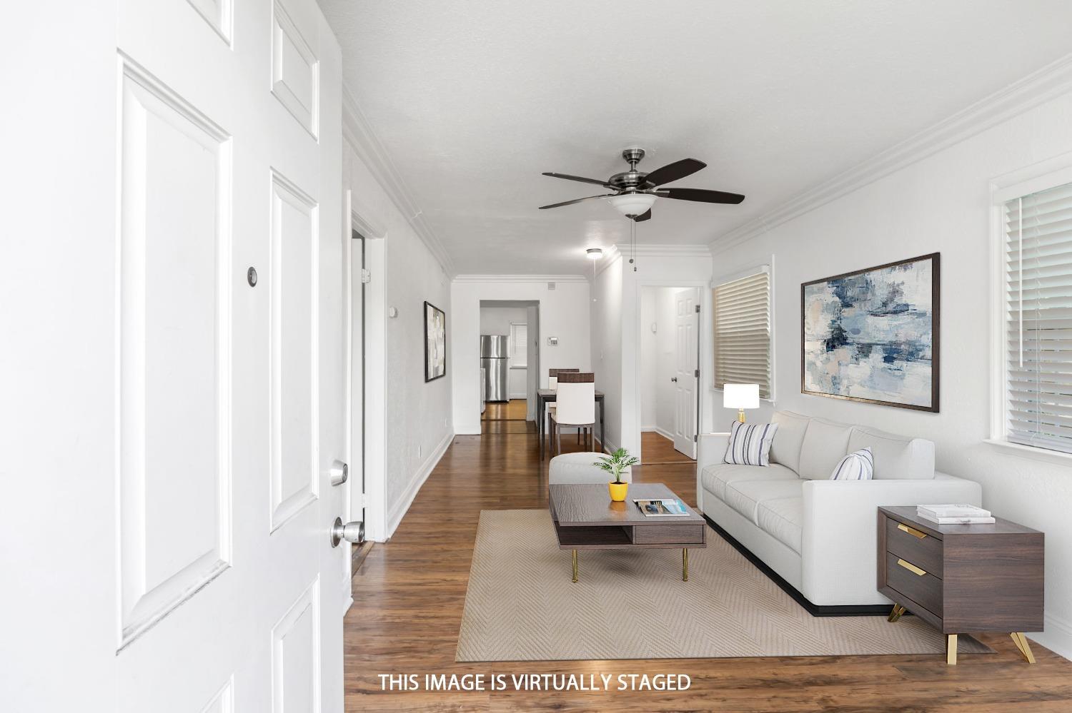 a living room with furniture and a ceiling fan