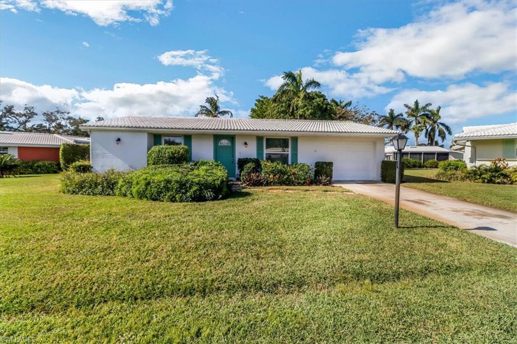 Single story home featuring a garage and a front yard