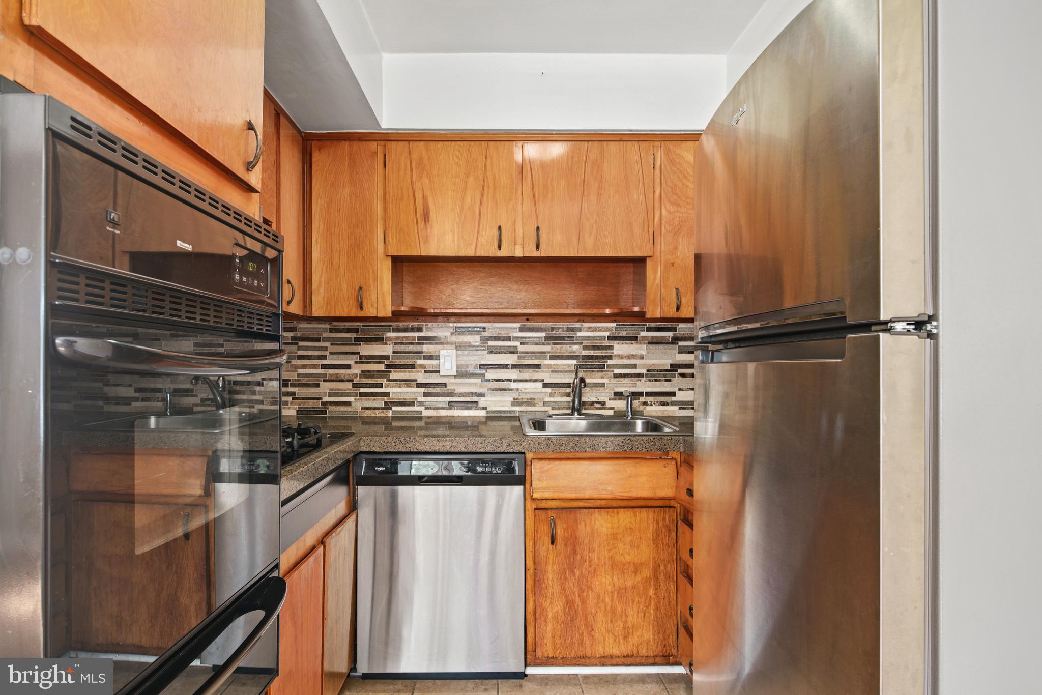 a kitchen with a refrigerator a stove top oven a sink and cabinets