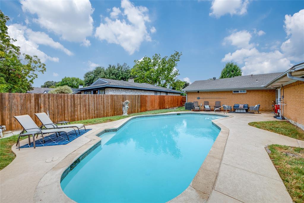 a swimming pool with outdoor seating and yard