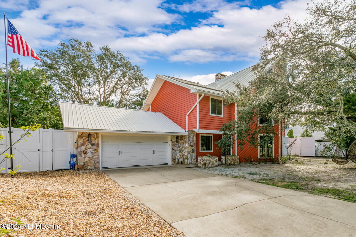 a view of a house with a yard and wooden fence