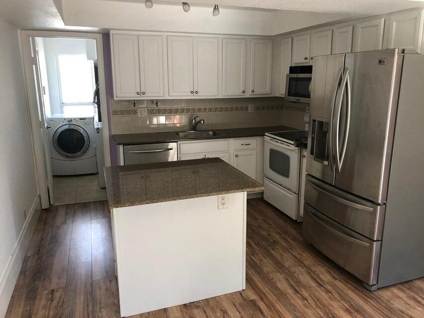 a kitchen with a refrigerator sink and cabinets