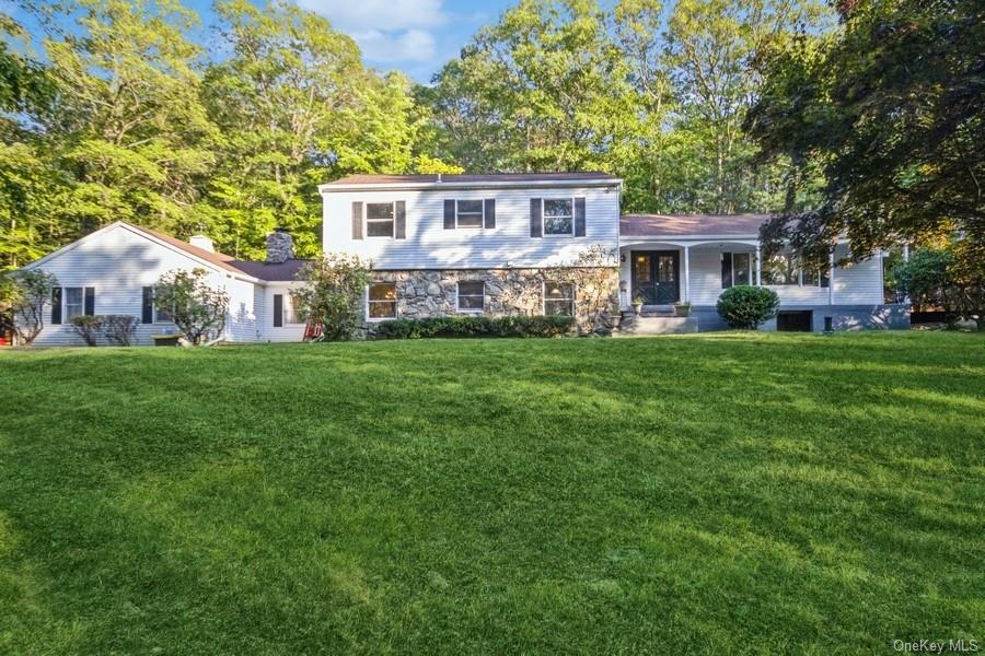 a view of a house with a big yard and large trees