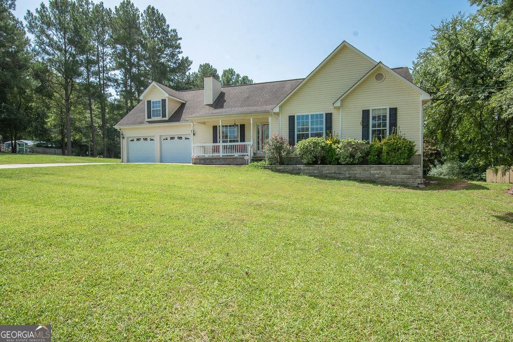 a front view of a house with a garden and yard