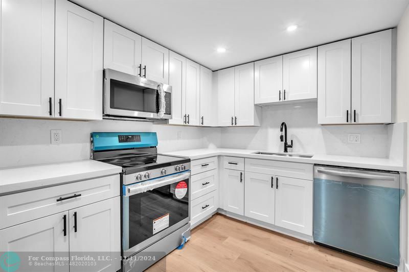 a kitchen with cabinets stainless steel appliances and sink