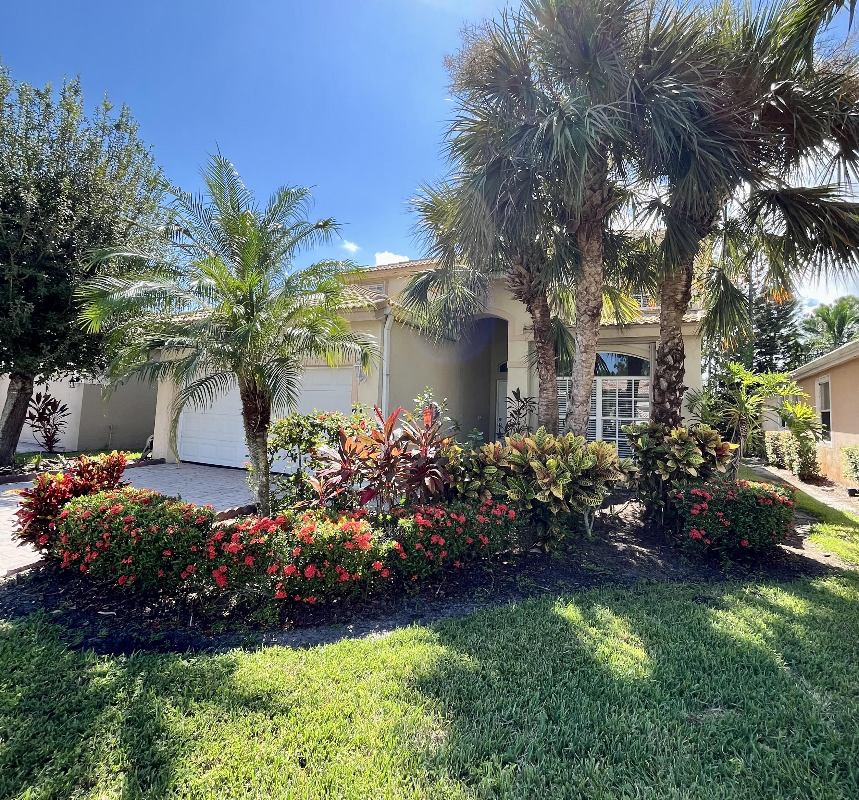 a front view of a house with a yard and fountain in middle