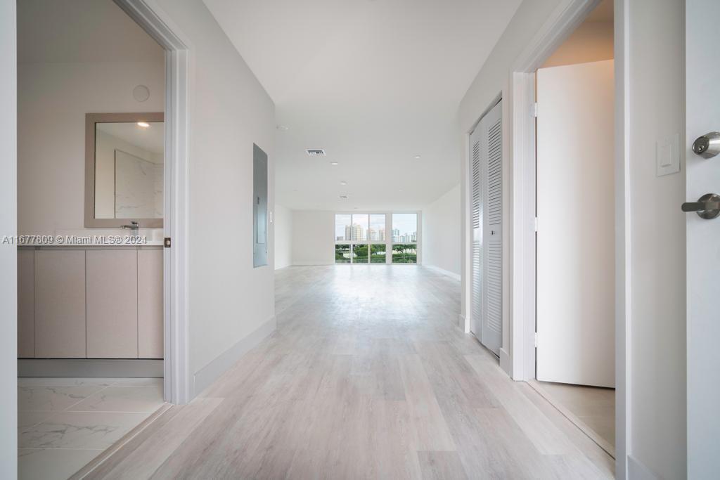 a view of a hallway view with wooden floor and a window