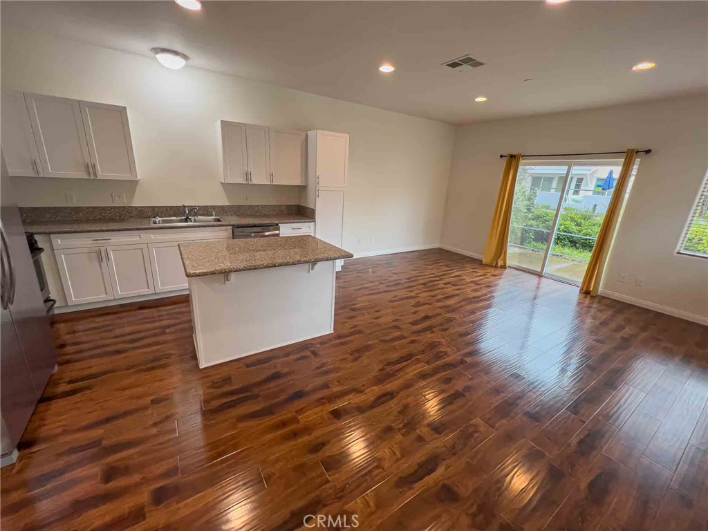 a kitchen with granite countertop a stove and wooden floor