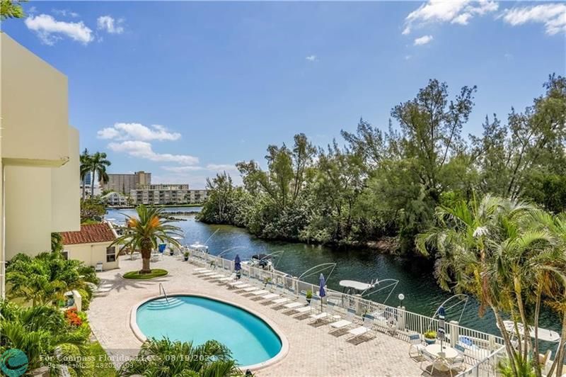 a view of a swimming pool with a patio and a yard