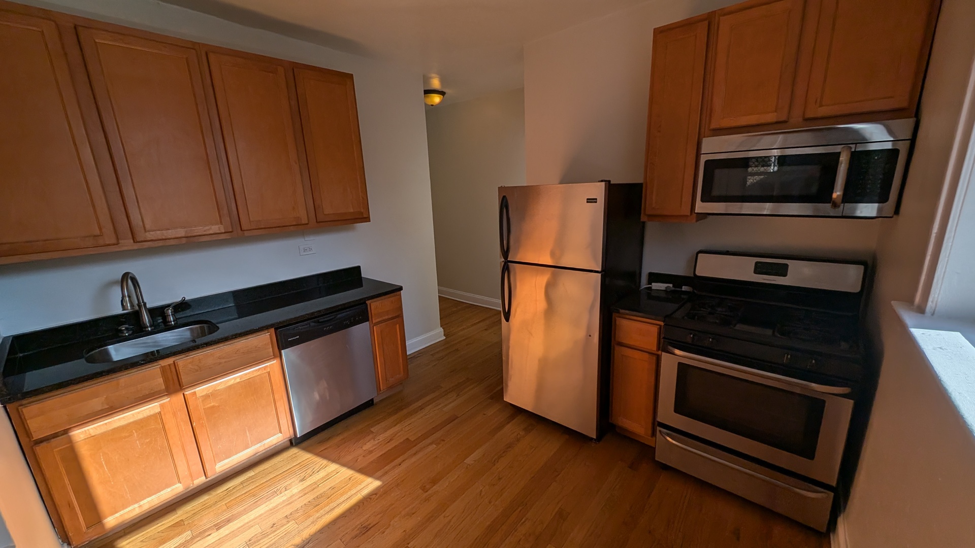 a kitchen with granite countertop wooden cabinets and stainless steel appliances