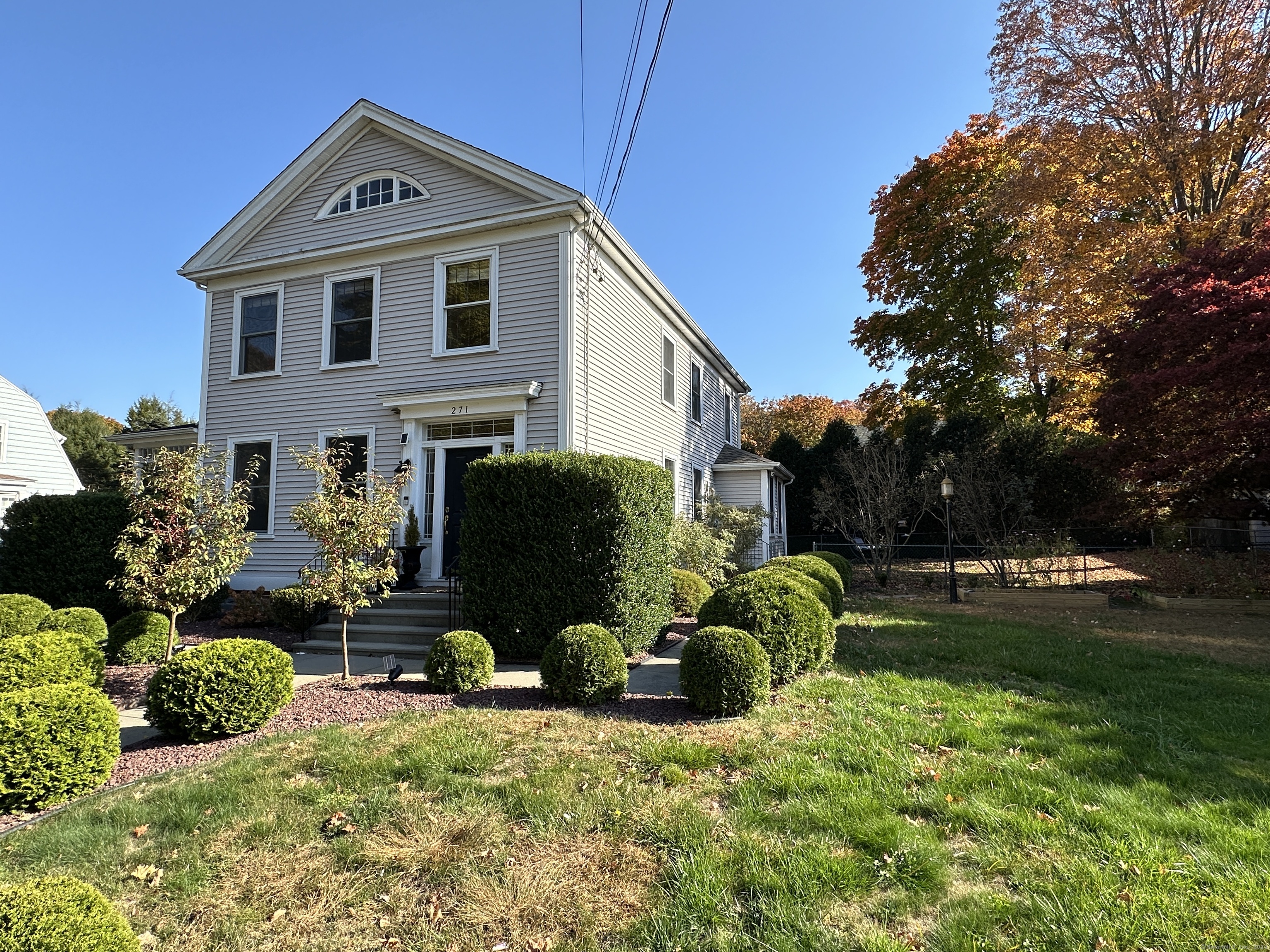 a front view of a house with garden and plants