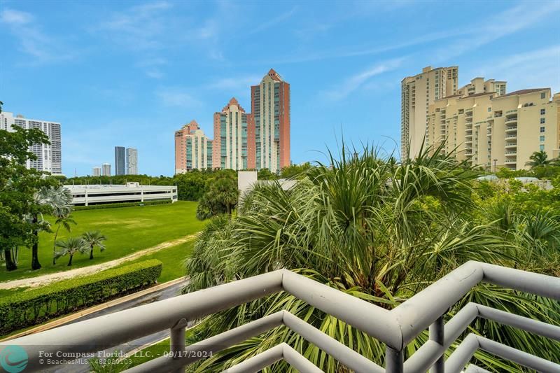 a view of a city from a balcony with chairs