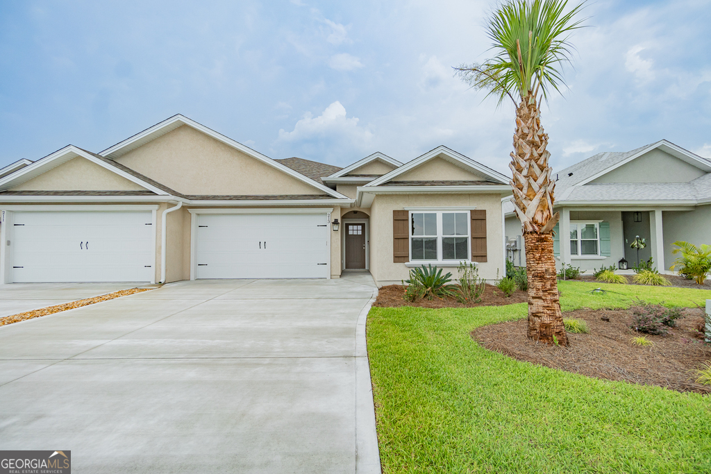 a front view of a house with yard and garage