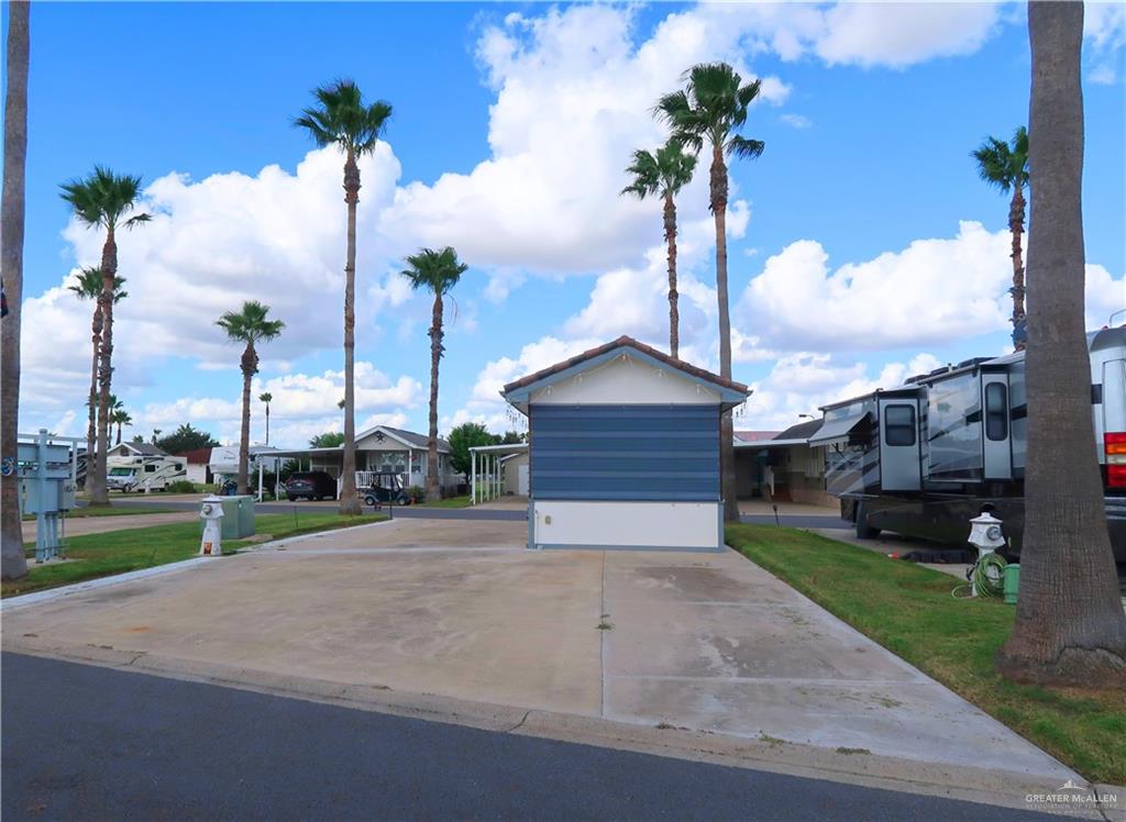 a view of a house with a yard and palm trees