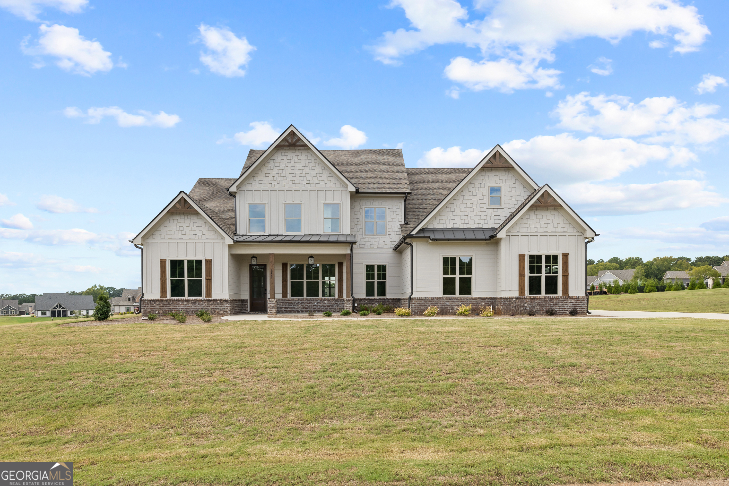 a front view of house with yard and ocean