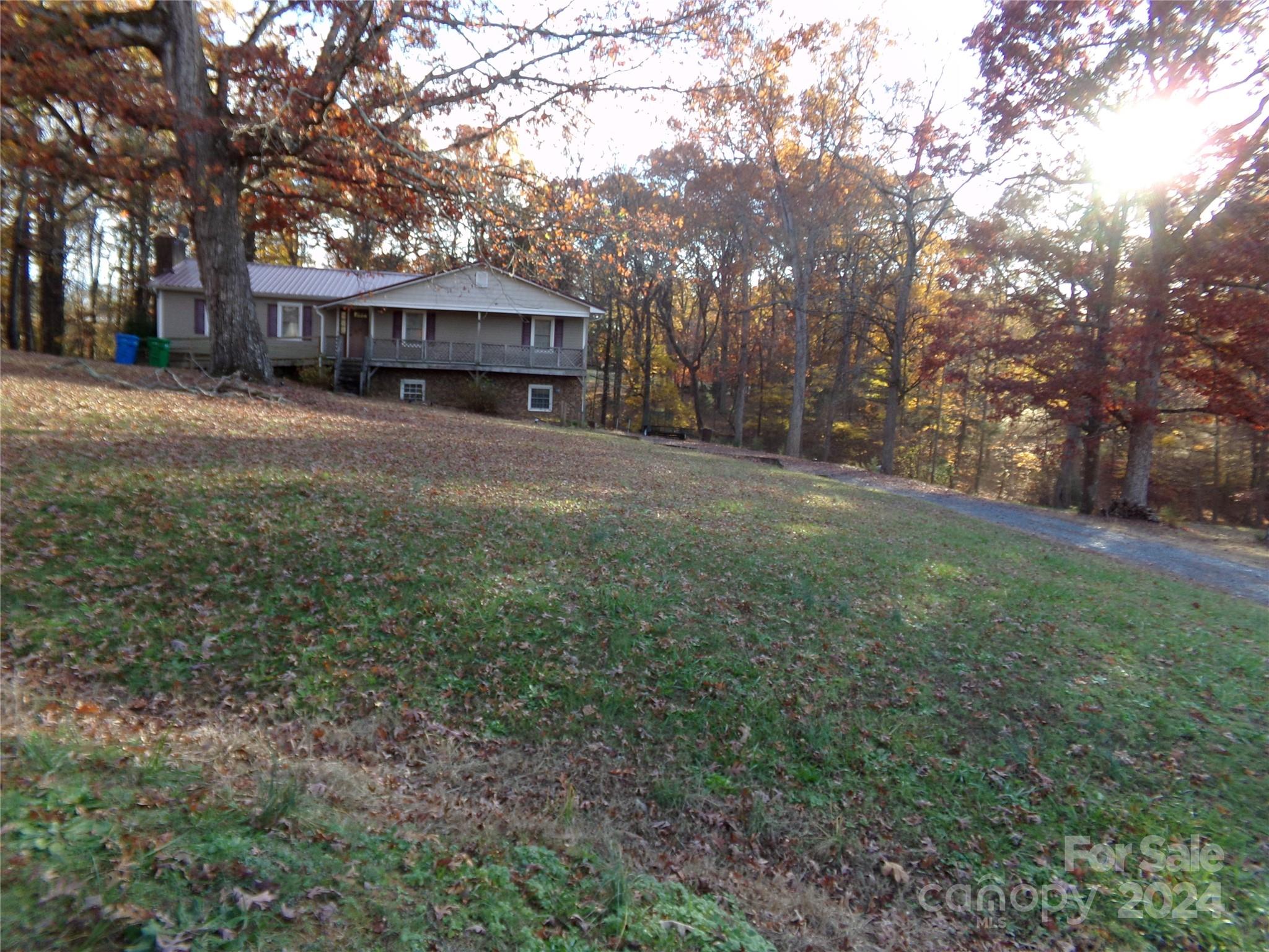 a view of house with yard and trees in the background