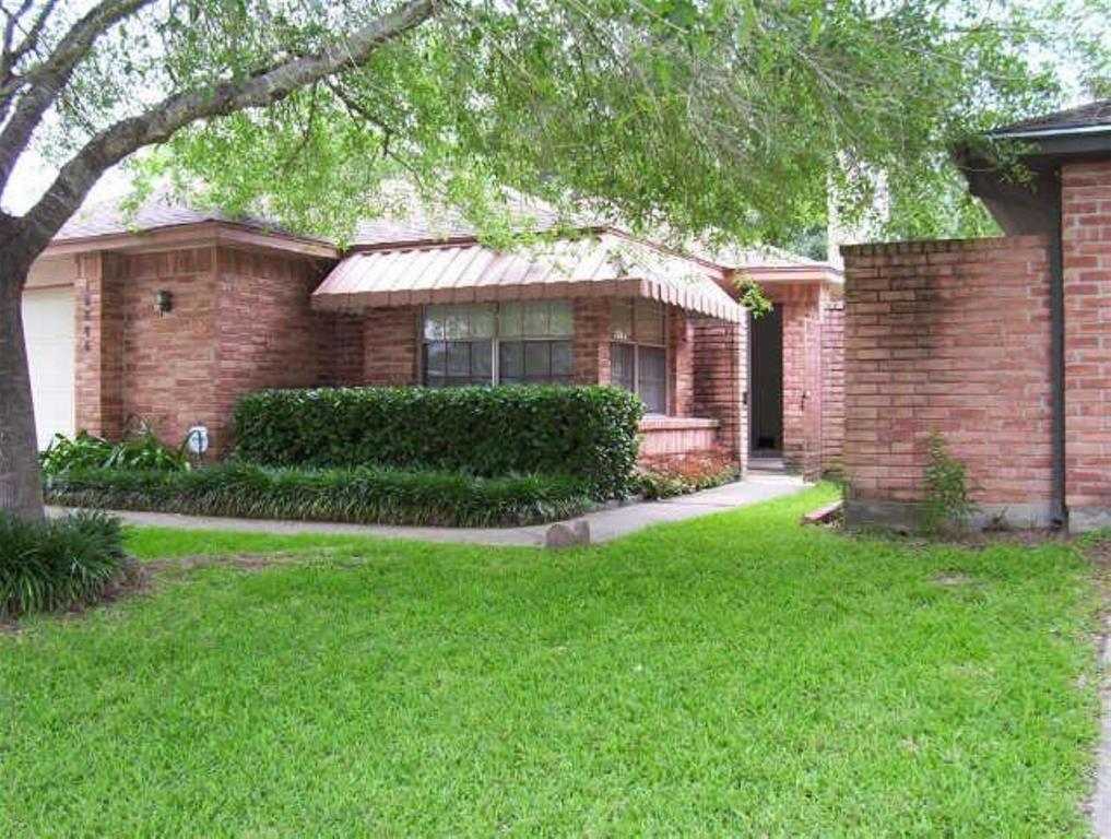 a front view of a house with a yard and green space