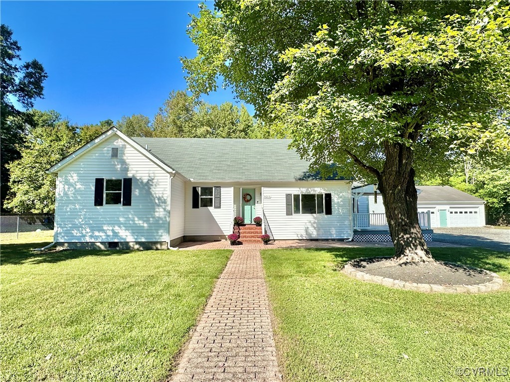 a front view of a house with a yard and trees