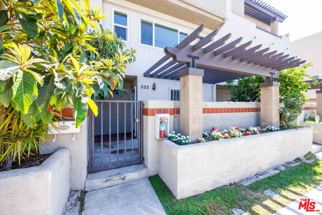 a front view of a house with plants