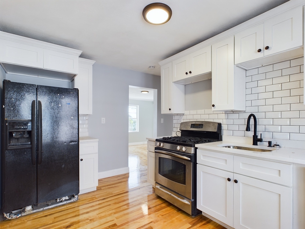 a kitchen with cabinets appliances and a wooden floor