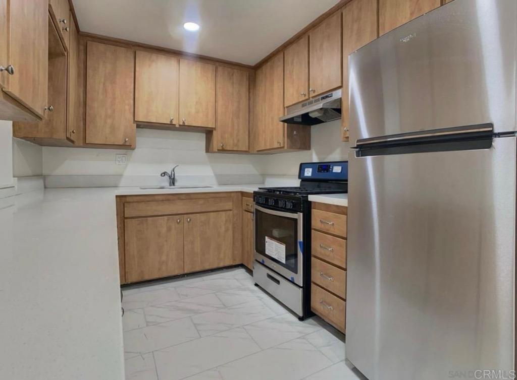 a kitchen with stainless steel appliances granite countertop a refrigerator sink and cabinets