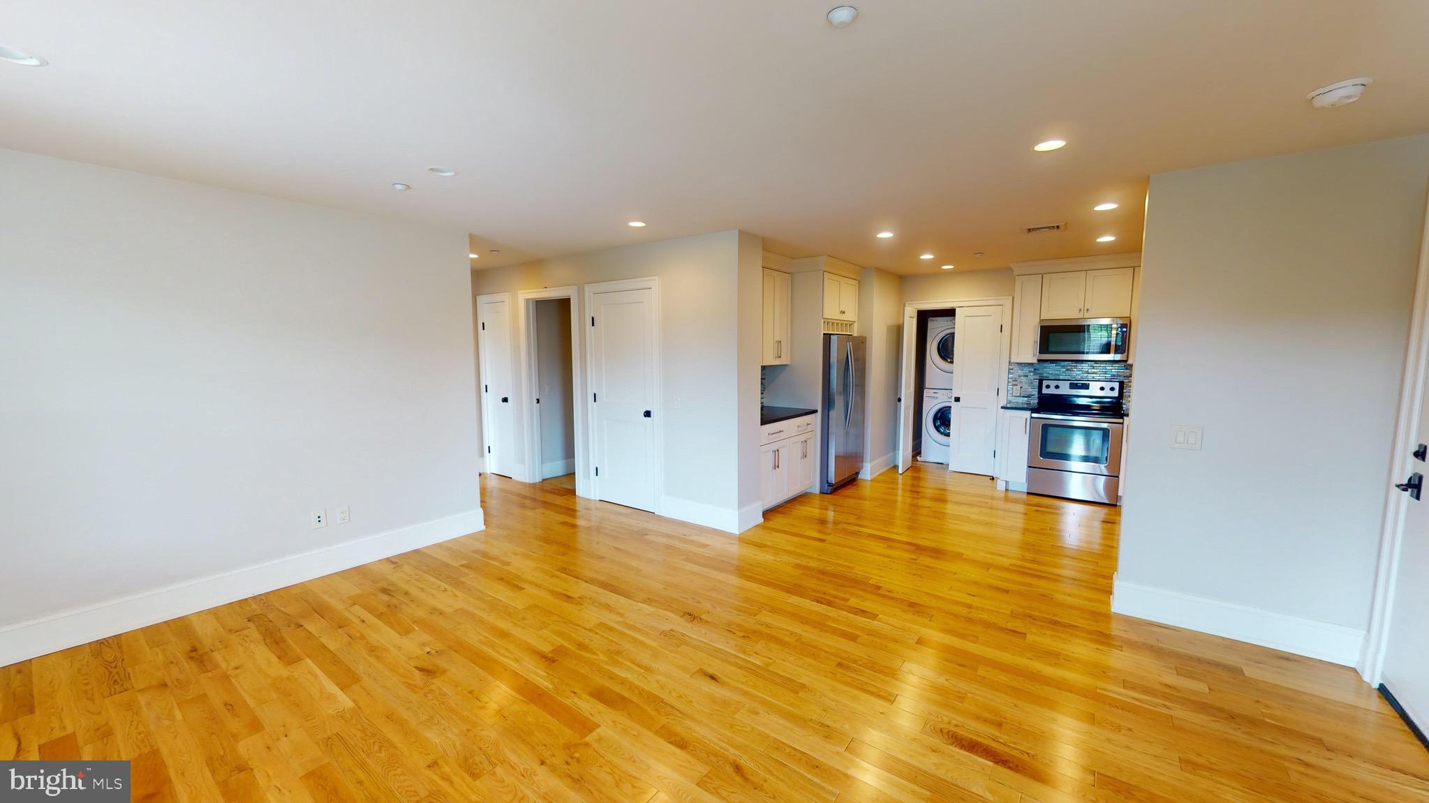 a view of empty room with kitchen natural light and kitchen view