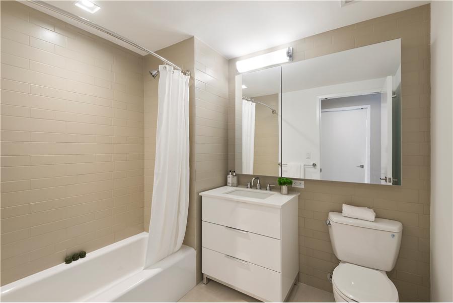 a bathroom with a granite countertop toilet sink and mirror