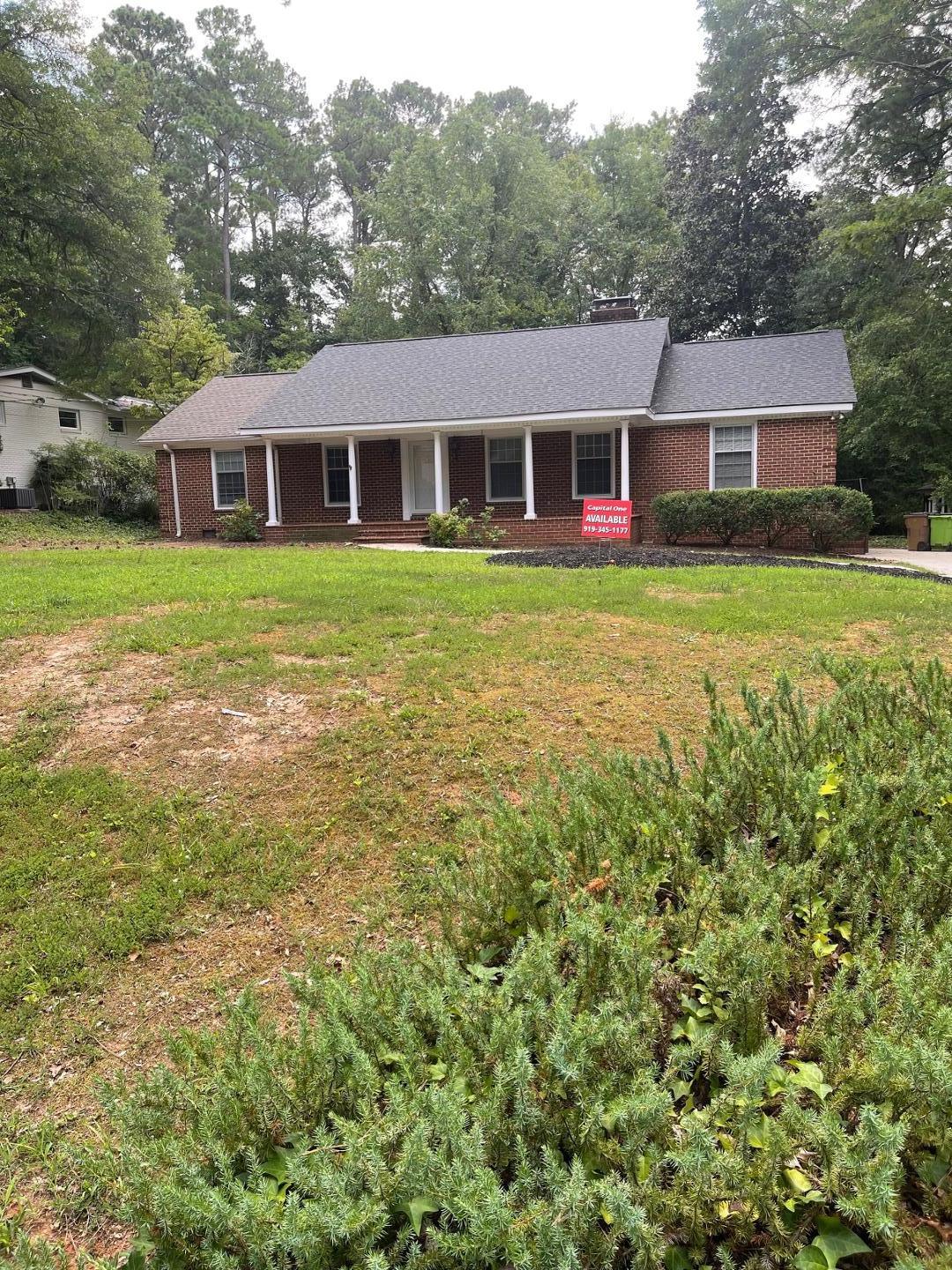 a front view of a house with yard and green space