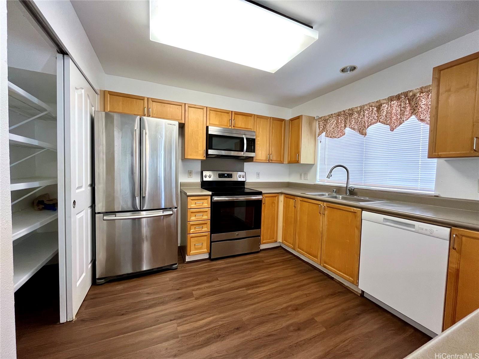 a kitchen with granite countertop a refrigerator and a sink