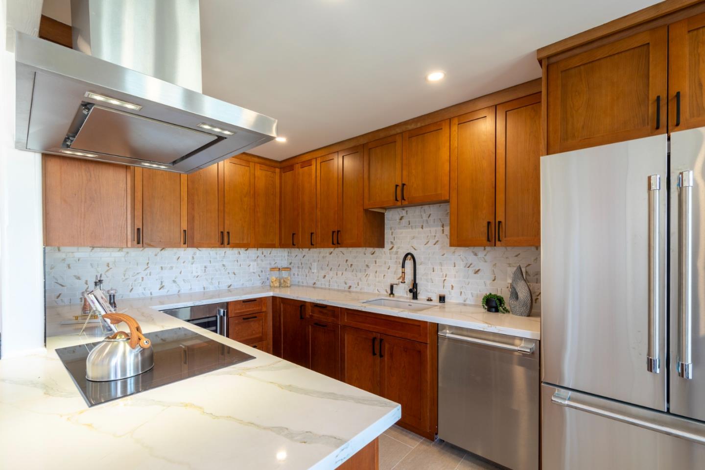 a kitchen with stainless steel appliances granite countertop a sink refrigerator and cabinets