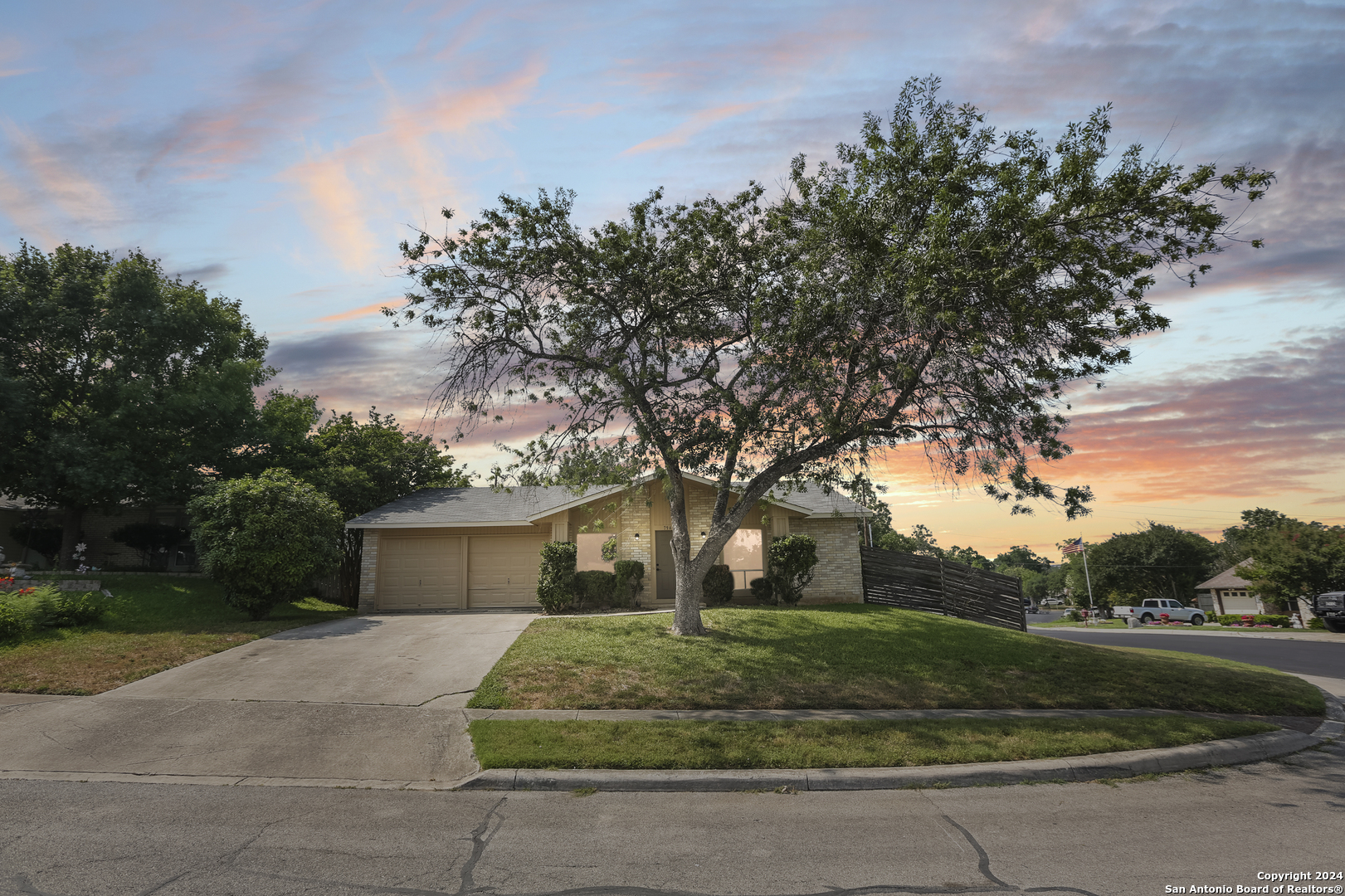 a front view of a house with a yard and trees