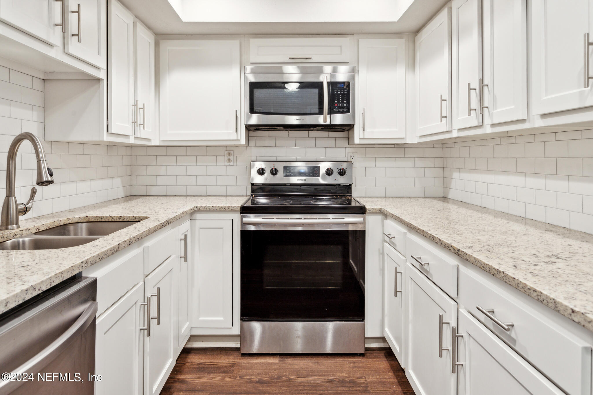 a kitchen with white cabinets and stainless steel appliances