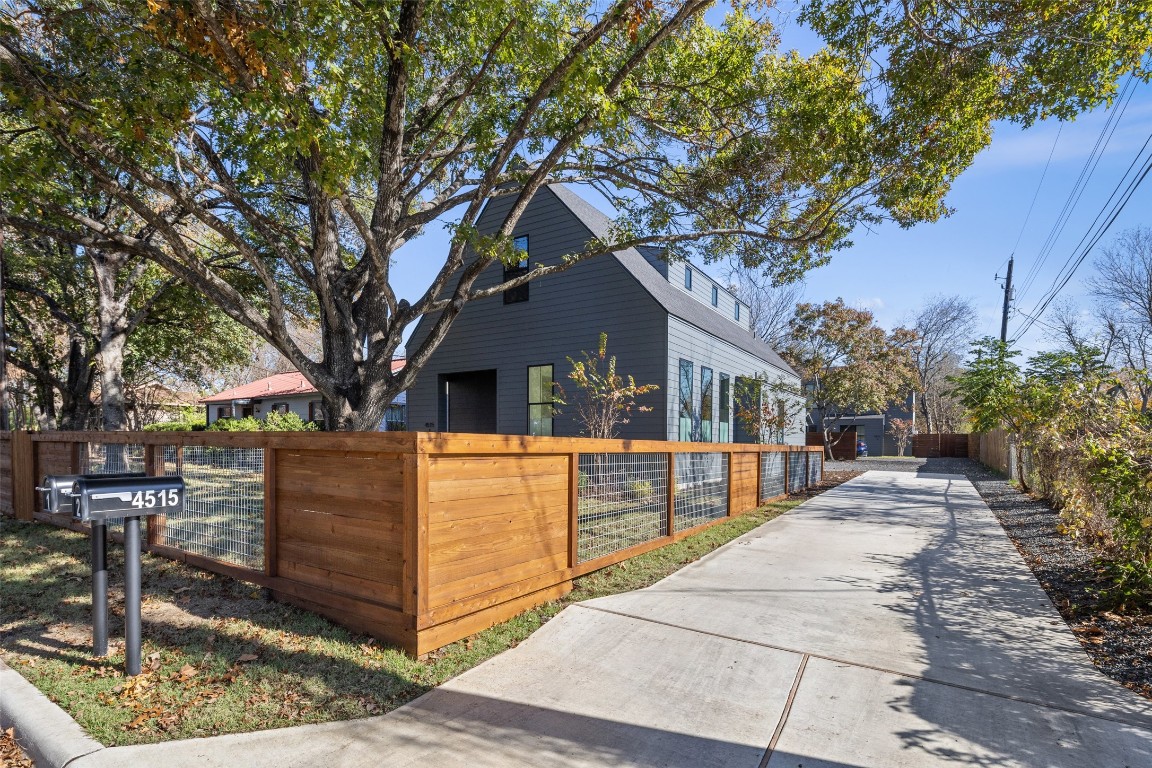 a front view of house with yard outdoor seating and covered with trees