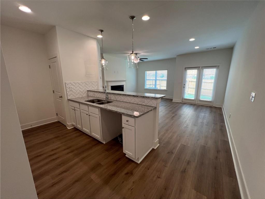 a kitchen with granite countertop a stove a sink and a refrigerator