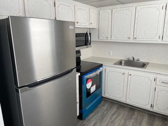 a kitchen with stainless steel appliances white cabinets and a refrigerator