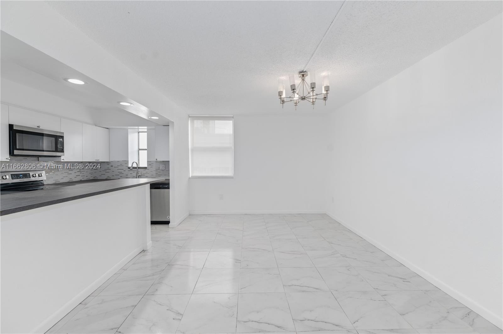 a large white kitchen with a sink and dishwasher