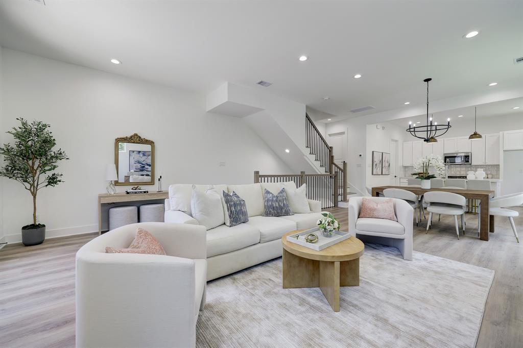 a living room with furniture and a view of kitchen