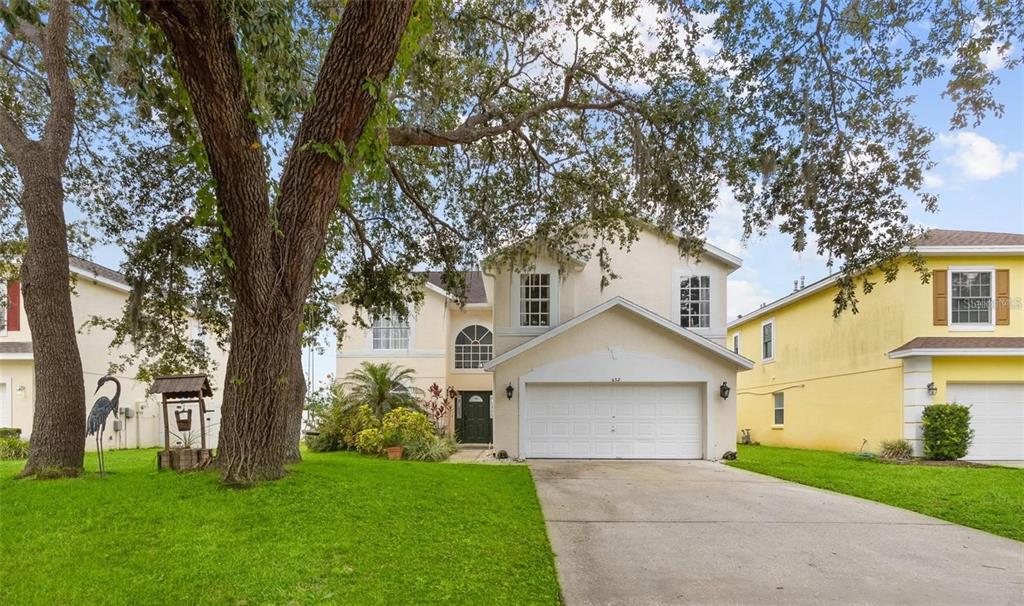 front view of a house with a yard and trees